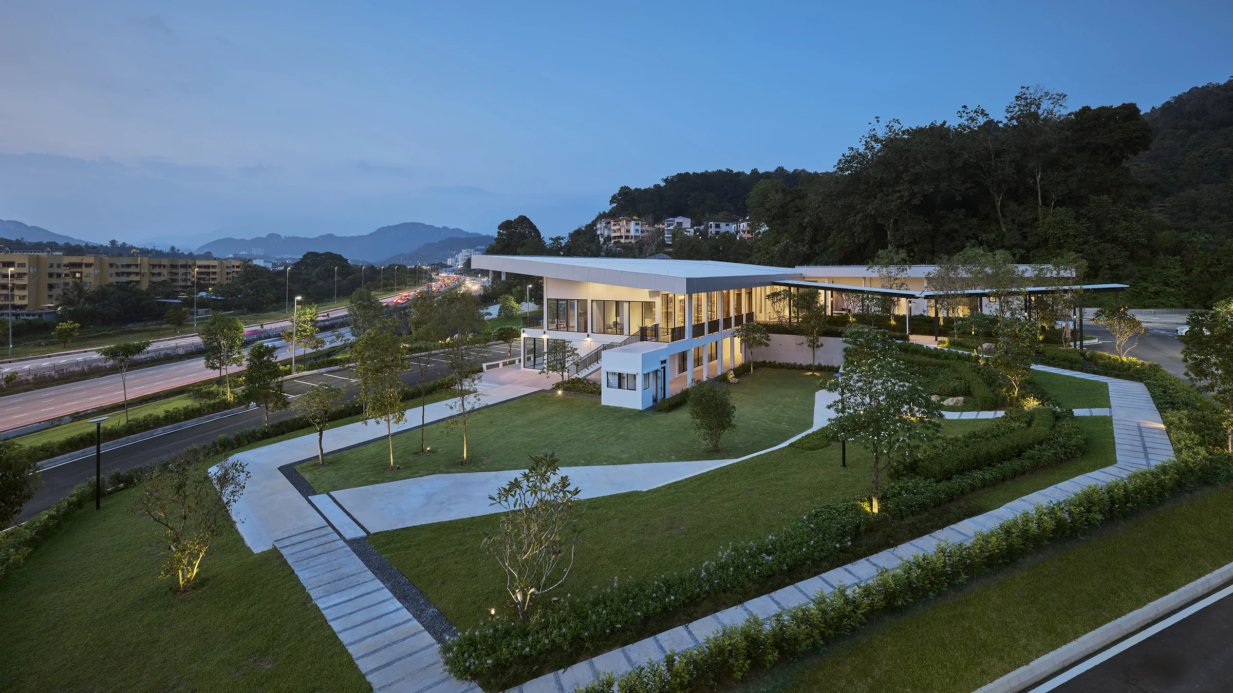 Aerial of the sales gallery and its gardens at dusk