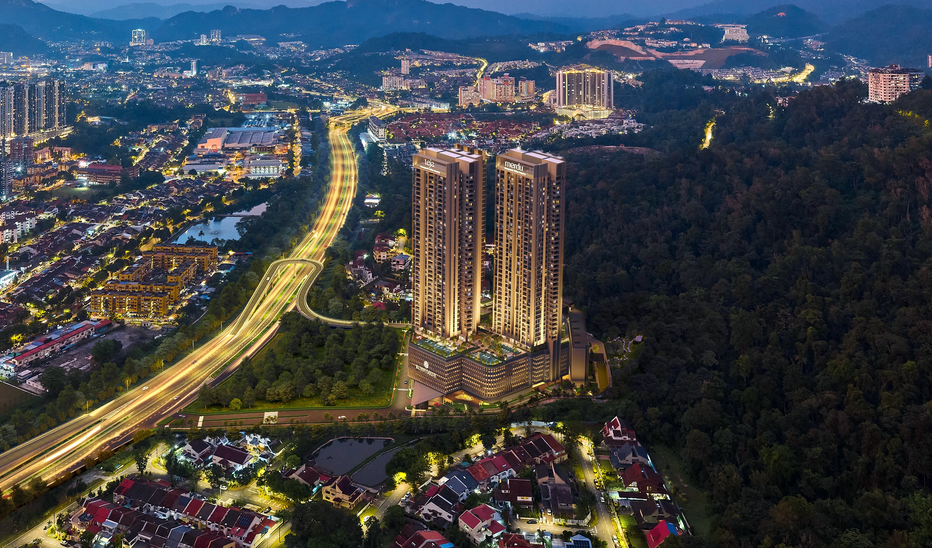 Night aerial of Runnymede Valley Ampang: the Teja and Merdu towers above their podium beside the MRR2, a flyover looping off the highway into the site, forested hills to the right